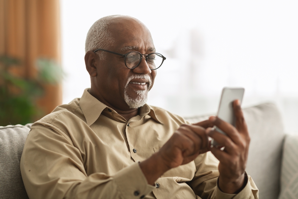 a senior man uses his smartphone