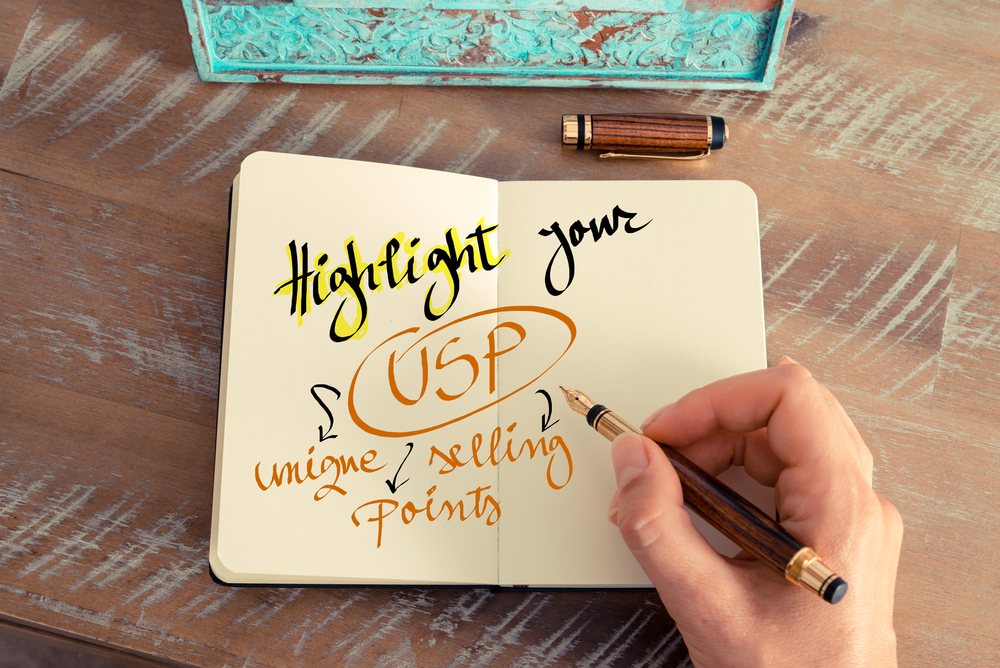 A journal with a notebook with the words, "highlight your unique selling points"